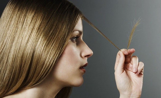 Woman Examining Split Ends --- Image by © Michael Haegele/Corbis